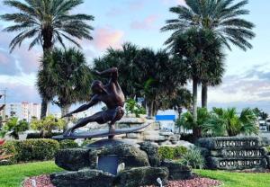 a statue of a surfer on a surfboard in a park at Unit 109 -1br Apt Oceanfront Complex With Pool in Cocoa Beach