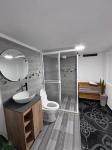 a bathroom with a toilet and a sink and a mirror at Mayka cabañas con JACUZZI in Guatapé +29 photos