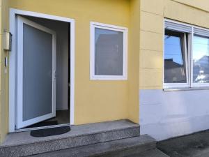 a yellow building with a door and two windows at WhiteWood-Apartment - Nähe A43 - zentral - inkl WiFi in Bockholt