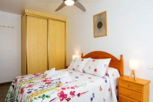 Un dormitorio con una cama con cabecero de madera. en Apartamento céntrico Belquimar a pocos pasos de la playa, en Carboneras