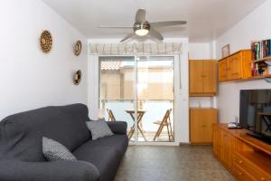 Una sala de estar con un sofá y un ventilador de techo. en Apartamento céntrico Belquimar a pocos pasos de la playa, en Carboneras