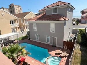 a house with a swimming pool in front of a house at Fam Reunion, Beachview, EV charger Heated Pool, Jacuzzi, Billiard in South Padre Island