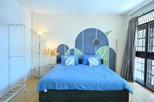 a bedroom with a blue bed with blue pillows at Moo Deng house Near old city,Street food Changpuek Market in Chiang Mai