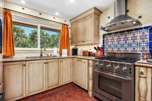 a kitchen with wooden cabinets and a stove top oven at Villa del Pacifico - SONG20 in Solana Beach