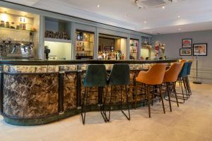 a bar with green and orange chairs in a room at Glasgow Argyle Hotel, BW Signature Collection in Glasgow