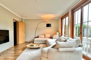 un soggiorno con due divani bianchi e un tavolo di 04 cosy family villa near Knokke Golf a Knokke-Heist