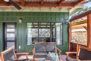 a green house with two chairs on a porch at Dew Drop Inn in Wimberley