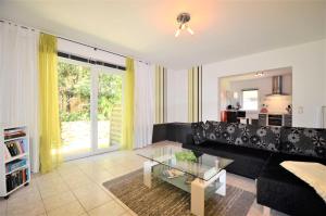 a living room with a black couch and a glass table at Ferienwohnung 300 Meter zur Ostsee in Graal-Müritz