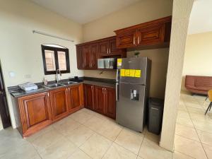 a kitchen with wooden cabinets and a stainless steel refrigerator at Los Olivos in Esquipulas