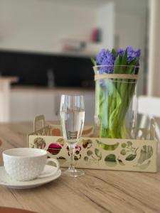 a table with a glass of wine and a vase of flowers at Hasselita in Hasselt +16 photos