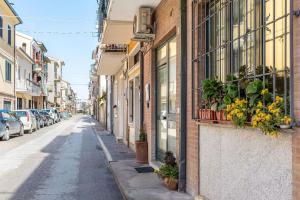 una strada cittadina con edifici e piante in vaso di Italian Experience-La Rondine Apartment a Porto Recanati