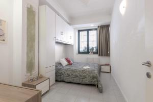 una piccola camera da letto con un letto e una finestra di Italian Experience-La Rondine Apartment a Porto Recanati