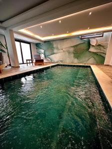 an indoor pool with green water in a house at Santa Barbara Sea front resort and spa in Polis Chrysochous
