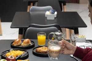 a person sitting at a table with breakfast foods and drinks at Hotel Gema Luxury Suites in Montevideo