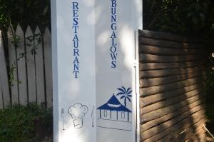 un panneau indiquant un restaurant à côté d'une clôture dans l'établissement Boraha Village Ecolodge, sur l'île Sainte-Marie