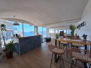 a restaurant with tables and chairs in a room with windows at Rallye Hotel in L'Escala