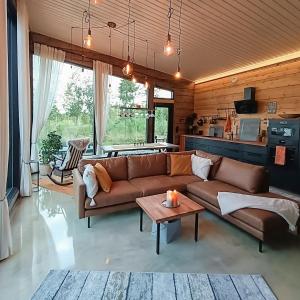 un soggiorno con divano marrone e tavolo di Villa Kokkoranta - Lake house with the View a Tampere