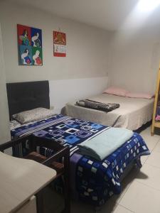 una habitación con dos camas y una mesa y sillas en La Casa De Los Amigos, en Arequipa