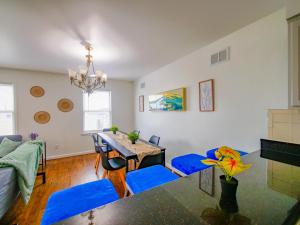 a living room with a dining room table and blue chairs at Impressive 3bed 2bath apt close to NYC in Jersey City