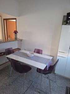 a kitchen with a table with chairs and a refrigerator at Morena in Pula
