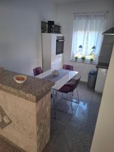 a kitchen with a table with chairs and a counter top at Morena in Pula