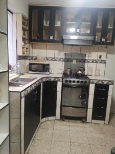 una cocina con estufa y microondas en La Casa De Los Amigos, en Arequipa