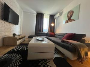 a living room with a couch and a table at VITRUVIAN Apartament 13 - Self check in 24h in Reşiţa