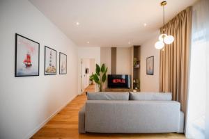 Exclusive 1BR Apartments in ONE Cotroceni في بوخارست: غرفة معيشة مع أريكة وتلفزيون