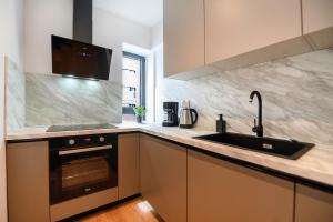 Exclusive 1BR Apartments in ONE Cotroceni في بوخارست: مطبخ مع حوض وموقد +37 صورة