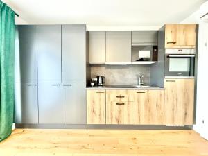 a kitchen with wooden cabinets and stainless steel appliances at Apartment mit Balkon und Parkplatz in Vienna