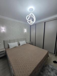 Un dormitorio con una cama grande y una lámpara de araña. en Modern comfort appartment, en Salor Bekati