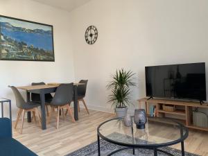 a living room with a table and a tv at Helle Freude! Modern Apartment in central Location in Neumünster