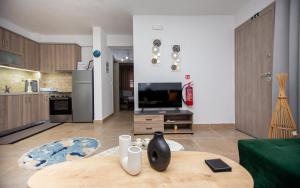 a living room with a table and a kitchen at LUNA'S HOUSE in Asprovalta