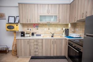a kitchen with wooden cabinets and a sink at LUNA'S HOUSE in Asprovalta