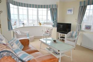 a living room with a couch and a table at Lighthouse Cottage, 19 Broadlands, Shaldon in Shaldon