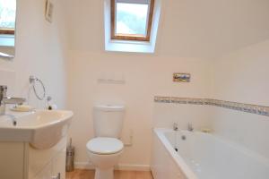 a bathroom with a toilet and a sink and a bath tub at Lighthouse Cottage, 19 Broadlands, Shaldon in Shaldon +12 photos