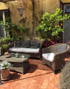 a patio with two chairs and a couch and a table at Terrazza Duomo in Naples