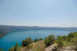a view of a blue lake on a hill at OSTELLO del Lago in Grottaferrata +9 photos