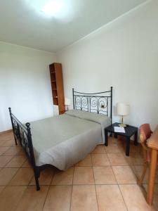 a bedroom with a bed and a table with a lamp at OSTELLO del Lago in Grottaferrata