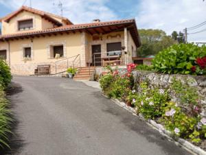 a house with flowers on the side of a road at La Casina in Celorio