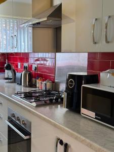 una cocina con estufa y microondas en 1 minute walk to Liverpool Stadium Free Private Parking, Anfield Liverpool Entire House, en Liverpool 13 fotos más