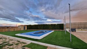 a small swimming pool in a yard with grass at La finca de Casa Botes in Cuenca