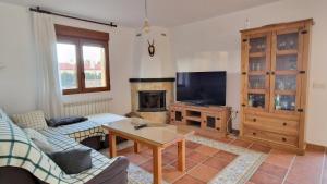 a living room with a tv and a fireplace at La finca de Casa Botes in Cuenca
