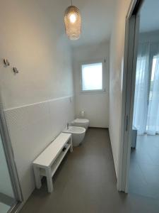 a white bathroom with two toilets and a sink at LuMa10 in Olbia +36 photos