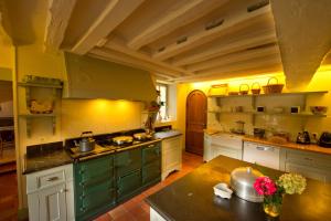 a kitchen with white cabinets and green appliances at Côté Jardin - Chambres d'hôtes in Senlis