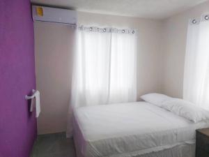 a small bedroom with a white bed and a window at ZenBreak Grateful no2 - 2bd A in Bridgetown