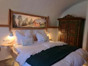 a bedroom with a bed with a painting on the wall at Apartment Tauernzwerg am Bauernhof in Ausserfragant