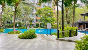 a resort with a pool and palm trees and a building at Digital Nomad Home Away With Pool & Gym in Nai Yang Beach