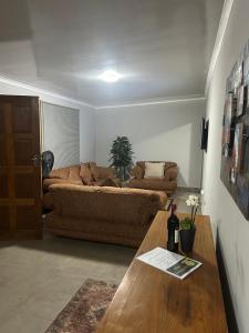 a living room with a couch and a table at Kufihliwe Lodge in Ingogo +2 photos