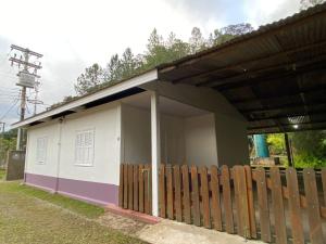 a small white house with a wooden fence at Legado das Águas in Miracatu